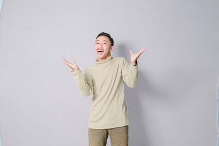 Asian youth is having euphoria, isolated on gray backgroundの写真素材
