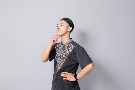young asian muslim thinking, isolated on gray backgroundの写真素材