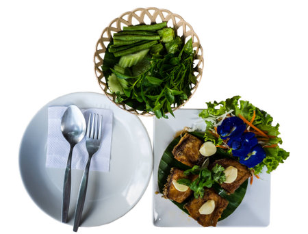 Thai food, prepare for eat spoon fork and dish with fried fish and vegetablesの写真素材