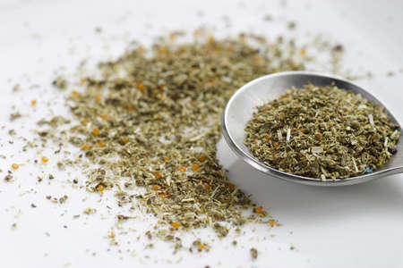 Chamomile tea leaves and tea spoon