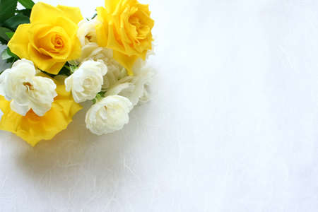 photo of a bouquet of yellow and white roses in the corner.の写真素材