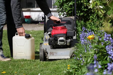 A man filled the tank of the mowerの写真素材