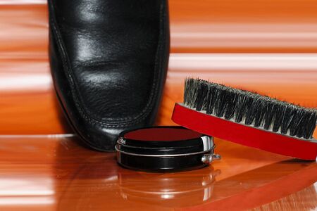 Shoe and brush isolated on a orange backgroundの写真素材
