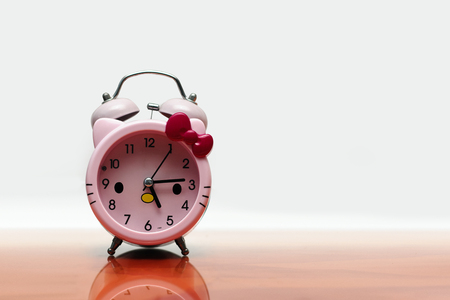 a pink alarm clock on the tableの写真素材