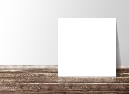 Blank white square paper template banner on the wooden floor against the wallの写真素材