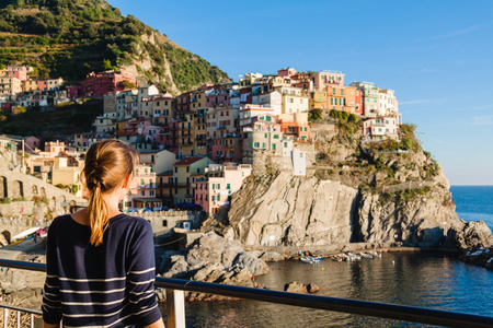 Young girl enjoying the view of Manarola in Cinque terre, Liguria, Italy.の写真素材