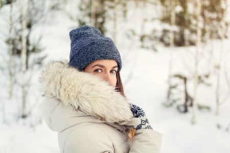 Christmas girl outdoor portrait. Woman in winter clothes on a snow field. Toned pictureの写真素材