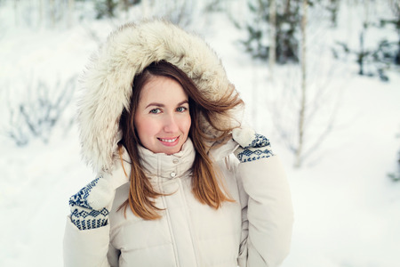 Christmas girl outdoor portrait. Woman in winter clothes on a snow field. Toned pictureの写真素材