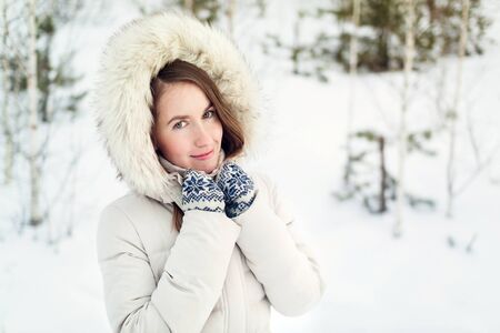 Christmas girl outdoor portrait. Woman in winter clothes on a snow field.の写真素材