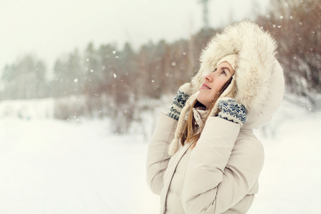 Christmas girl outdoor portrait. Woman in winter clothes on a snow field. Toned pictureの写真素材