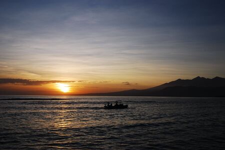 Sunset with fishermen's boat in Bali, Indonesia