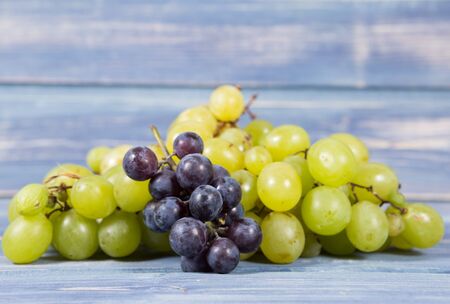 Closeup of organic farm grapes on blue wood background as autumn or fall harvest conceptの写真素材