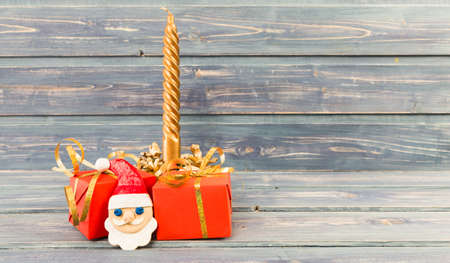 Christmas holiday gifts golden candle an santa's face made of cookies on wooden backgroundの写真素材