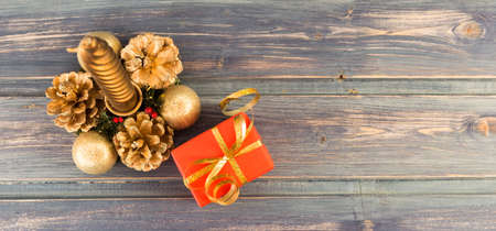Golden Christmas candle and red gift on wooden board with copy spaceの写真素材