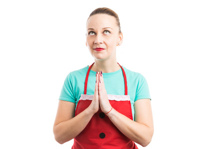 Cleaning lady or housekeeper praying with palms together isolated on white backgroundの写真素材
