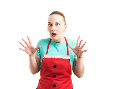Woman wearing red apron acting scared as panic and anxiety concept isolated on white backgroundの写真素材