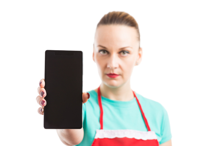 Female wearing red apron showing smartphone or cellphone blank screen with copyspace and text areaの写真素材