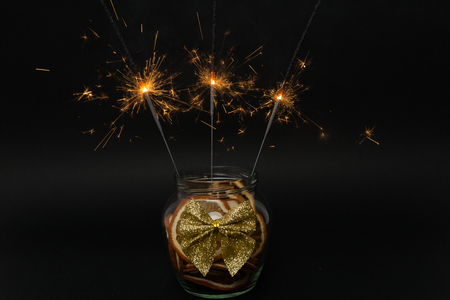 Small sparkling fireworks on dry orange slices jar as Christmas or new year celebration conceptの写真素材