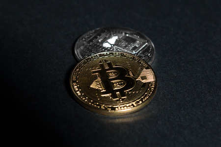 Two coins as bitcoins concept isolated on dark black background table or boardの写真素材