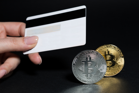 Buy bitcoins online using credit or debit card concept on dark black backgroundの写真素材