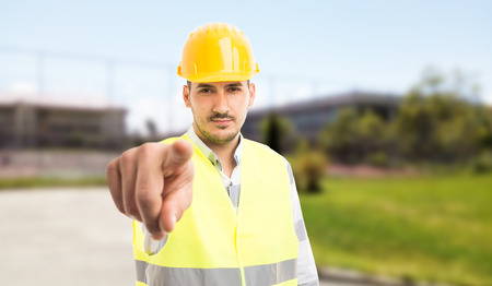 Workman or constructor pointing finger at camera with mad attitude as blame concept outdoors