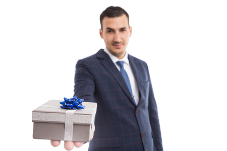 Young hansome elegant husband or boyfriend offering present as holiday celebration gift concept isolated on white backgroundの写真素材