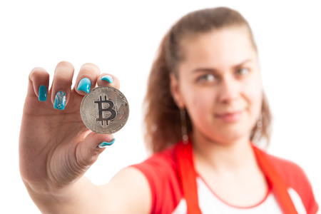 Young woman retailer or sales assistant holding bitcoin symbol as cryptocurrency online payment concept isolated on white backgroundの写真素材
