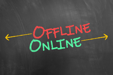 Offline and online chalk text on blackboard or chalkboard as working on internet marketing conceptの写真素材