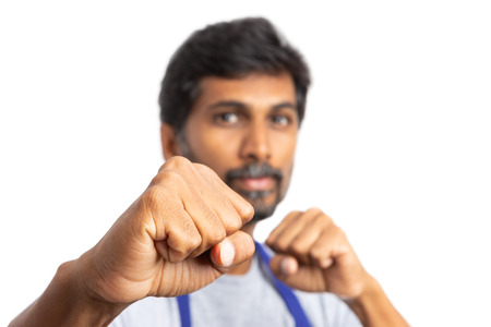 Close-up focused fist of supermarket or hypermarket indian man employee as punching concept isolated...