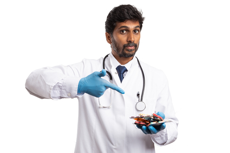 Indian medic indicating handful of medicine with index finger isolated on white studio backgroundの写真素材