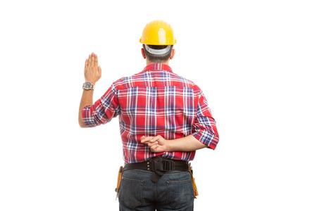 Lying constructor doing unsincere oath with palm raised and crossed fingers behind back isolated on...