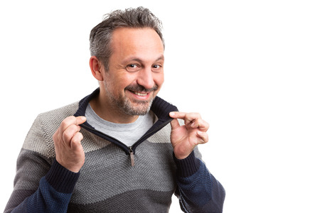Smiling man arranging winter sweater collar with hands isolated on white background