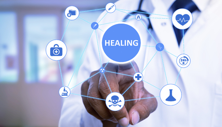 Indian physician or doctor man choosing with index finger healing button on transparent screen among...