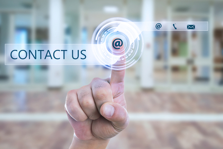 Closeup of person touching email sign with index finger on transparent display as contact us conceptの写真素材