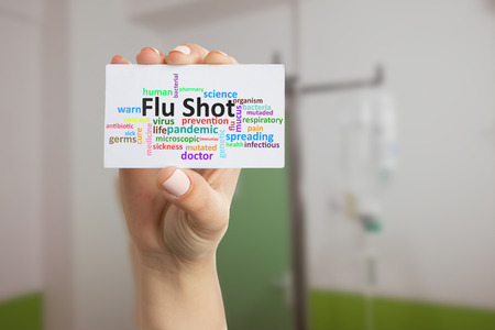 Medic woman holding white paper card with flu shot text as prevention concept closeupの写真素材