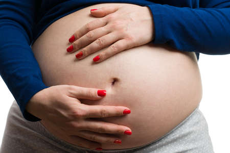Close-up of future mother grabbing her tummy as happy expecting concept on white background