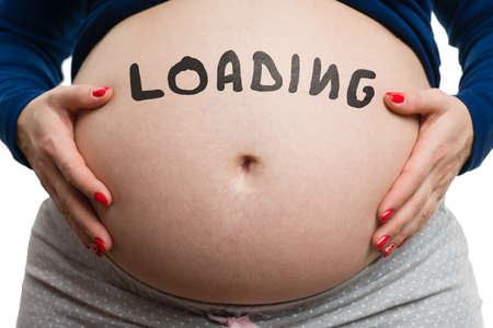 Close-up of pregnant woman belly with black loading text isolated on white background as expecting conceptの写真素材