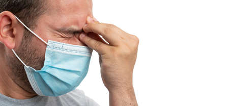 Close-up of thinking adult man touching forehead using fingers as stress headache concept wearing...