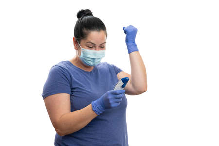 Happy woman adult model checking body temperature on laser thermometer wearing disposable surgical...