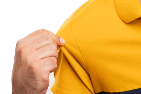 Close-up of adult man model presenting yellow casual summer stylish modern tshirt using fingers isolated on white studio backgroundの写真素材
