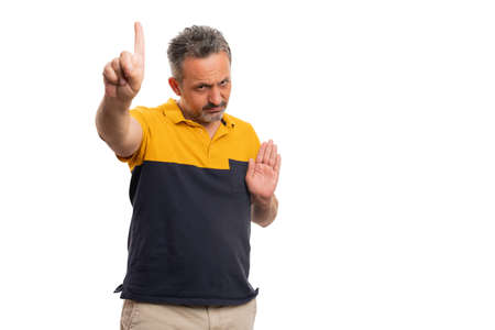 Angry adult man with serious expression making no stop stay away gesture using index finger and palm...