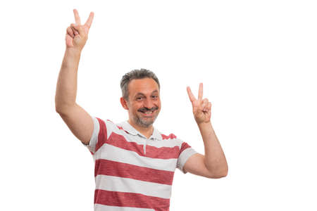 Friendly male model showing cheerful smile making peace or victory sign with fingers wearing casual summer polo-shirt with collar isolated on white studio background blank copyspace for textの写真素材