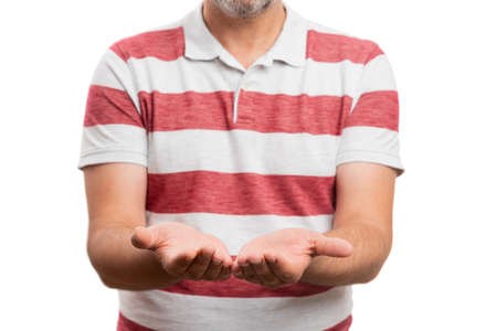 Close-up of male adult model wearing tshirt summer clothing making holding gesture using palms hands as blank copyspace area for text and advertising isolated on white backgroundの写真素材