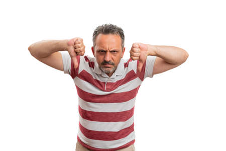 Adult male model with angry annoyed expression making double thumbs-down dislike disapprove gesture...