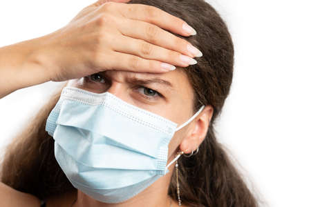 Close-up of adult female model touching forehead as high body temperature fever cold or covid19 flu...