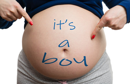 Close-up of pregnant mom showing belly with its a boy text as gender reveal concept isolated on...