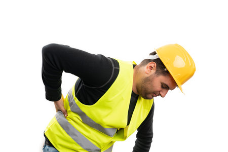 Builder man wearing yellow safety hardhat and fluorescent vest as work equipment with back pain...