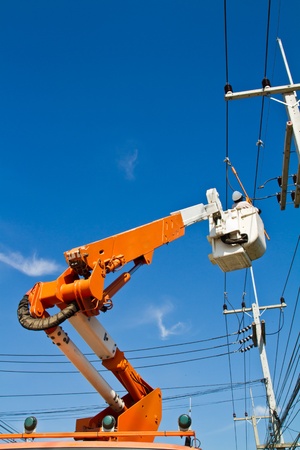 Electrician is repairing high tension power lineの写真素材