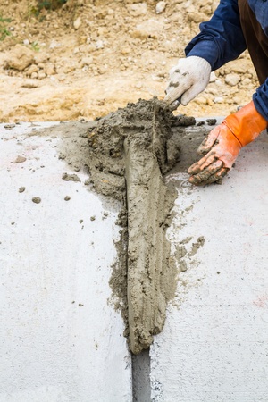 Hand using trowel to finish on concrete drainage pipe 