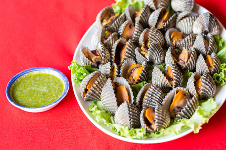 Boiled fresh cockles on lettuce vegetable for seafood serving